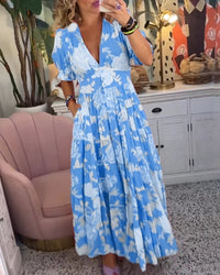 Robe longue bleue à col en V, vue de côté, manches bouffantes, imprimé floral.