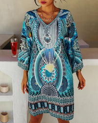 Robe courte d’été turquoise à col V, motif mandala central et bordures géométriques.