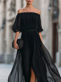 Robe longue noire en mousseline, épaules dénudées avec volants, ceinture froncée.