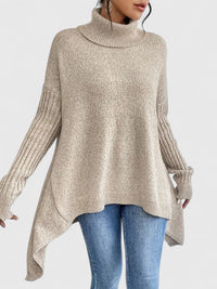 Col roulé en maille chaude beige clair, coupe ample avec pan allongé, manches côtelées.