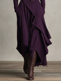 Robe violette drapée, gros plan sur les pans asymétriques et le tissu fluide