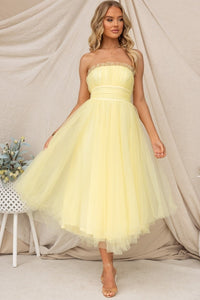 Robe longue Aera en tulle jaune pâle, décolleté bandeau et jupe superposée légère.