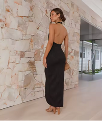 Robe midi plissée noire dos nu, coupe longue et fente au bas.