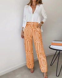 Ensemble deux pièces : blouse blanche, pantalon orange à motifs et ceinture à boucle