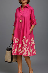Robe midi chemise rose fuchsia, col boutonné, bord imprimé feuilles blanches.