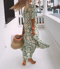 Robe longue vert motif floral abstrait, encolure en V, manches courtes, ourlet volanté.