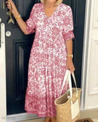 Robe midi rose à motif floral, encolure V, manches courtes, jupe évasée à volants.