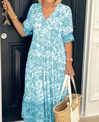 Robe midi turquoise à motif floral, base à volants, encolure V et manches bouffantes.