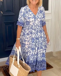 Robe midi bleue à motif floral, manches bouffantes, empiècement volanté au buste.
