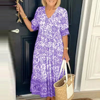 Robe midi violette à motif floral, encolure V, manches courtes bouffantes, plis au bas.