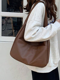 Sac porté épaule marron, porté à l’épaule, anse courte et face lisse.