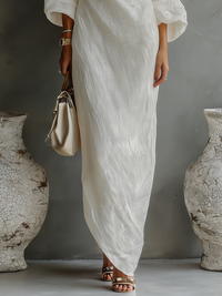 Robe longue fluide ivoire, vue rapprochée bas du vêtement et ourlet asymétrique.