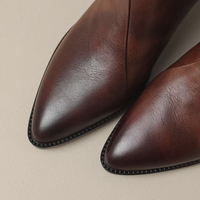 Bottes élégantes en cuir marron foncé, bouts arrondis et surpiqûres décoratives