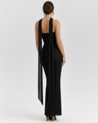 Robe longue noire au dos nu, col montant, fente drapée au bas du vêtement
