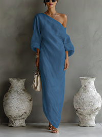 Robe longue fluide bleue à une épaule, manches amples, drapé ample jusqu’aux chevilles.