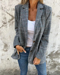 Blazer à carreaux bleu-gris, revers en pointe, boutonnage et poches avant.