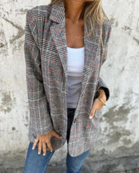 Blazer à carreaux gris avec fines lignes rouges, col tailleur et poches avant.