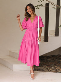 Robe longue rose fuchsia à encolure V, manches bouffantes, jupe évasée à volants.
