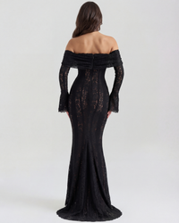 Robe longue noire en dentelle, vue de dos, épaules dénudées et ourlet évasé avec fente.