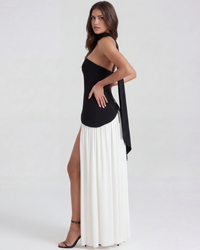 Robe Serena vue de profil : corset bandeau noir et jupe longue blanche plissée fendue