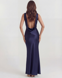 Robe longue satinée bleu nuit, dos ouvert, lignes cintrées et fente en bas.