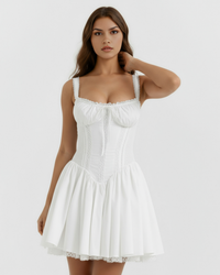 Robe courte blanche à bretelles, corset à lacets et jupe plissée, dentelle au bas.