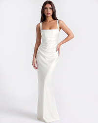 Robe longue ivoire à fines bretelles, coupe ajustée et drapés sur le buste