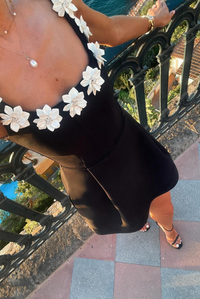Robe courte noire à fleurs blanches sur le haut et décolleté ouvert