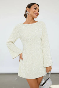 Robe à sequins ivoire, manches longues, nœud noir au dos.