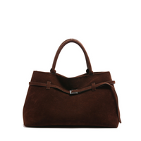 Sac en daim marron avec anses courtes et fermeture à boucle métallique.