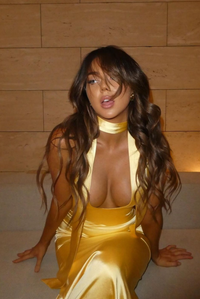 Robe longue en satin jaune doré, encolure halter et décolleté, ajustée au buste.
