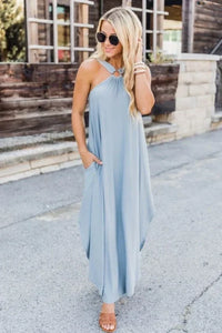 Robe midi bleu clair sans manches, encolure croisée, tombé ample et fente discrète.