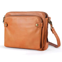 Sac à main en cuir marron clair, bandoulière réglable et fermeture zippée.