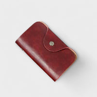 Pochette vintage en cuir bordeaux avec rabat arrondi et bouton-pression métallique