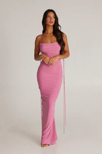 Robe longue lilas à fines bretelles, buste froncé, coupe près du corps.