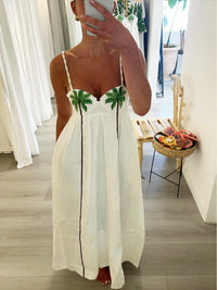 Robe longue blanche à bretelles fines, imprimé palmiers verts, coupe ample.