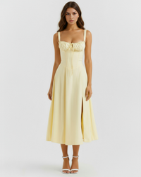 Robe midi jaune à bretelles fines, empiècement froncé poitrine et fente devant.