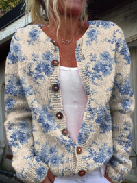 Cardigan floral bleu à boutons marron, encolure ronde, fond écru, manches longues.