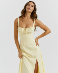 Robe midi jaune à bretelles fines, corset cintré, cordon au buste et fente.