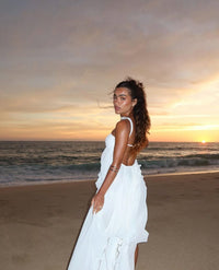 Robe longue Collins blanche avec bretelles fines, jupe à volants et appliqué discret