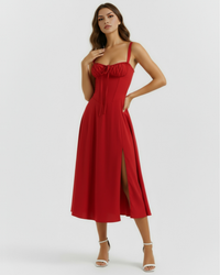 Robe midi rouge à bretelles fines, décolleté froncé, jupe fendue sur le côté.