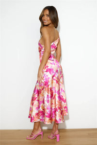 Robe midi asymétrique une épaule, vue de dos, imprimé floral rose et violet, dos nu partiel.