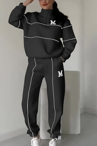 Ensemble pull et pantalon noir avec surpiqûres blanches contrastantes, logo M sur poitrine