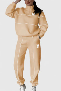Ensemble pull et pantalon beige clair avec lignes contrastées blanches, logo M