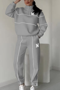 Ensemble pull et pantalon gris clair, col montant zippé, bandes contrastées et broderie M