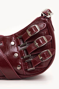 Petit sac bordeaux en cuir, sangles à trois boucles, rivets et poche zippée