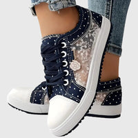 Baskets orthopédiques bleu foncé à lacets, motifs fleurs et pois, semelle blanche.