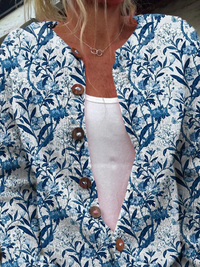 Cardigan floral bleu et blanc, boutons marron sur l’avant, encolure V et manches longues