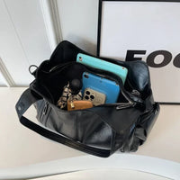 Sac cabas en cuir noir, ouverture zippée, rangement avec poches pour téléphone.