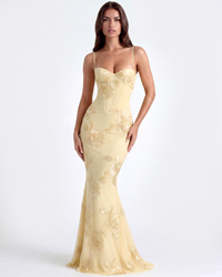 Robe longue Denise dorée à bretelles fines, motifs floraux brodés et silhouette moulante.